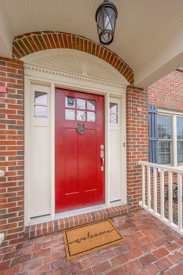 view of exterior entry featuring brick siding