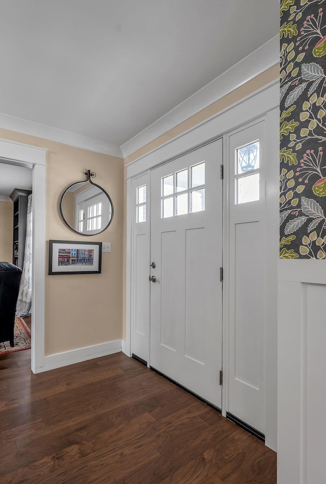 foyer featuring crown molding, baseboards, and dark wood-style flooring