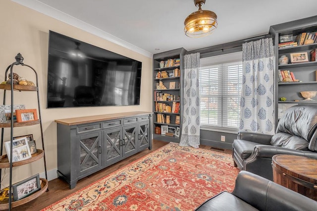 living room featuring visible vents, ornamental molding, baseboards, and wood finished floors