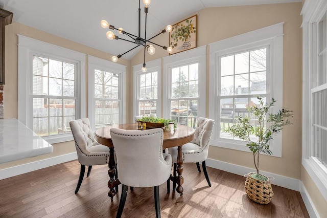 dining room featuring an inviting chandelier, plenty of natural light, and vaulted ceiling