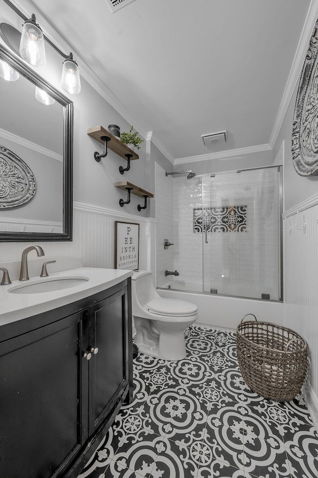 full bath featuring tile patterned floors, a wainscoted wall, toilet, and ornamental molding