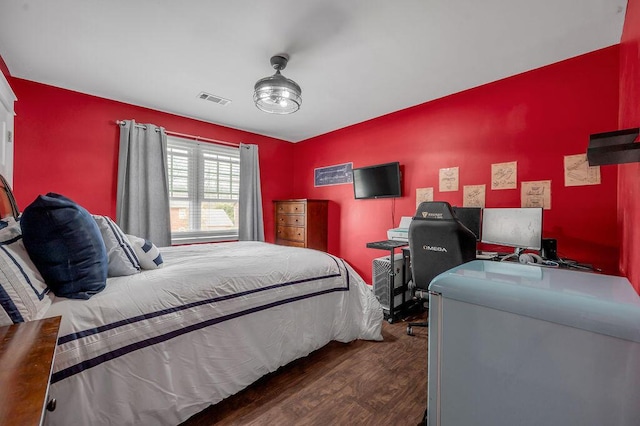 bedroom featuring visible vents and wood finished floors