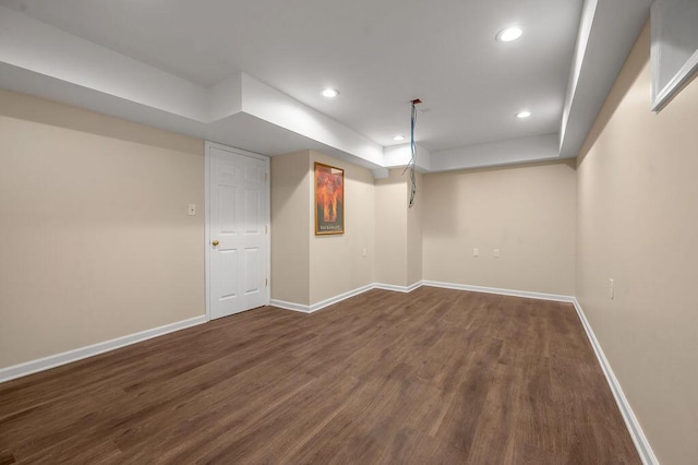 finished basement featuring dark wood-type flooring, recessed lighting, and baseboards