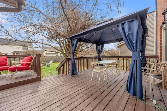 wooden terrace with a gazebo and fence