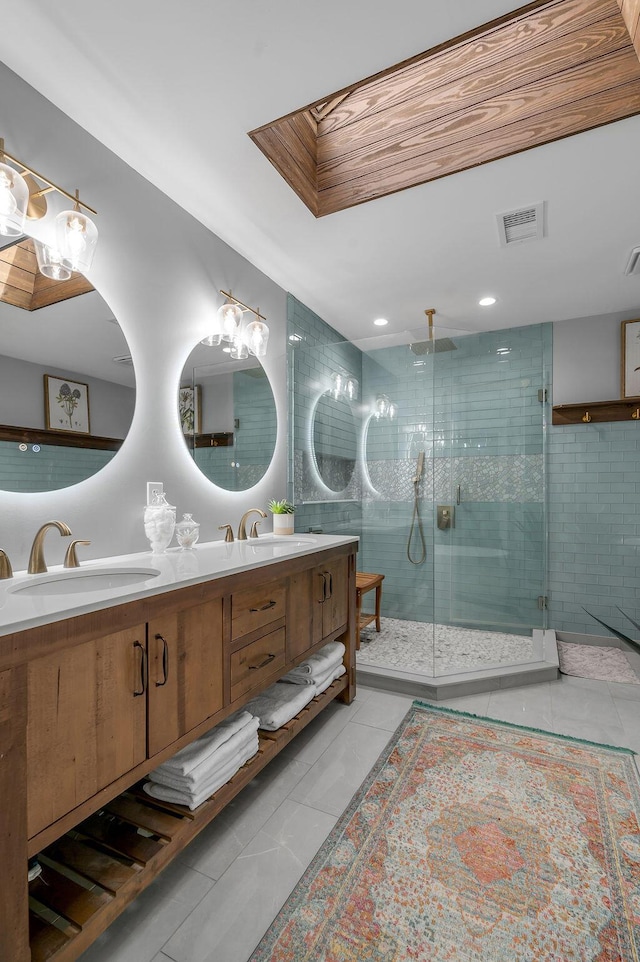 full bath featuring tile patterned flooring, a shower stall, double vanity, and a sink