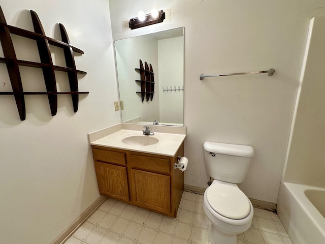 bathroom with vanity, a tub to relax in, baseboards, tile patterned floors, and toilet