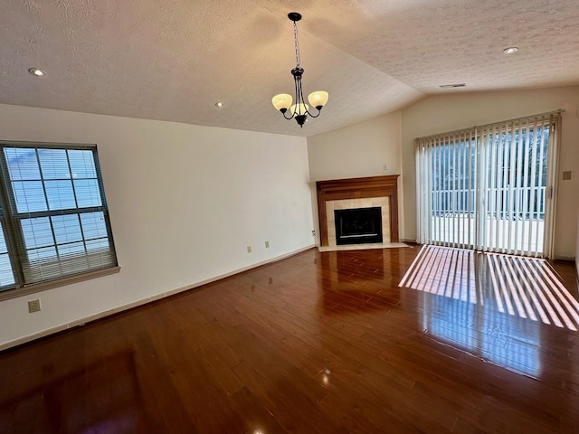 unfurnished living room with baseboards, lofted ceiling, a healthy amount of sunlight, and wood finished floors