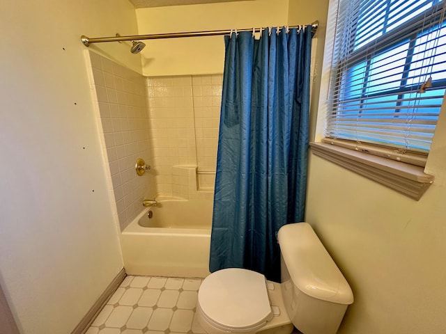 bathroom with tile patterned floors, toilet, shower / tub combo with curtain, and baseboards