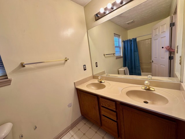 bathroom with a sink, toilet, and tile patterned floors