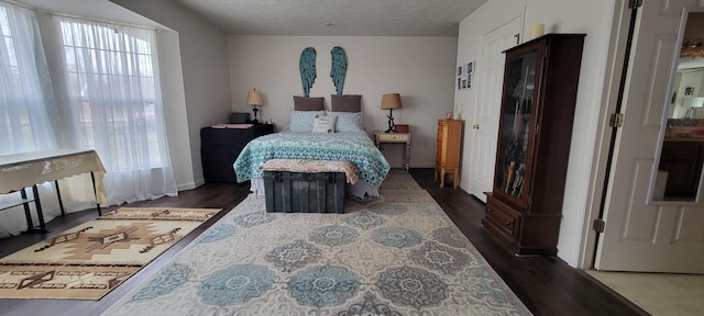 bedroom with dark wood-style floors and a textured ceiling