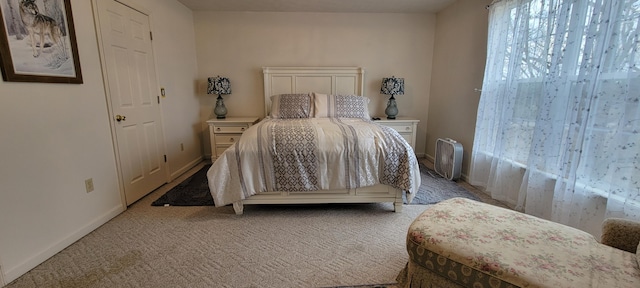 bedroom featuring baseboards and light carpet