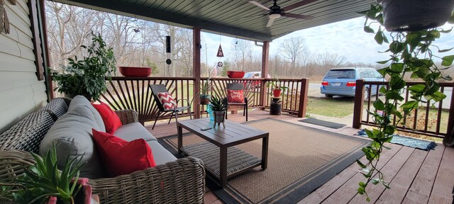 wooden terrace with an outdoor living space and a ceiling fan