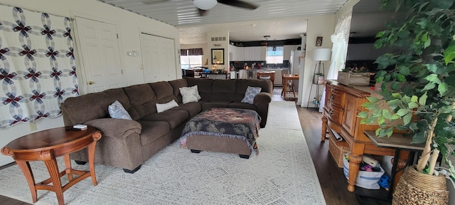 living area with a ceiling fan and light wood-type flooring