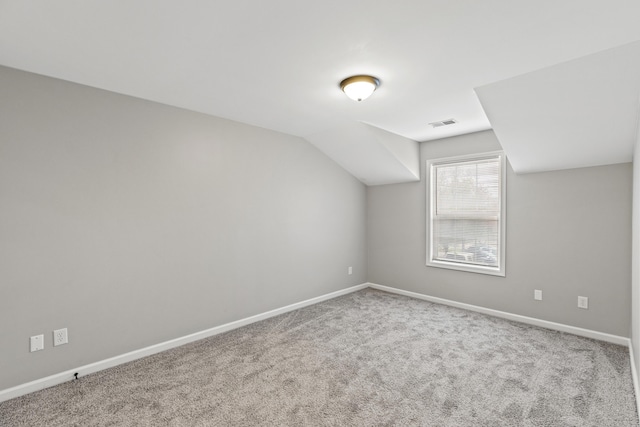 additional living space featuring vaulted ceiling, carpet, visible vents, and baseboards