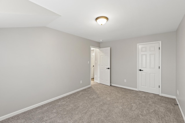 unfurnished bedroom with lofted ceiling, baseboards, and carpet floors