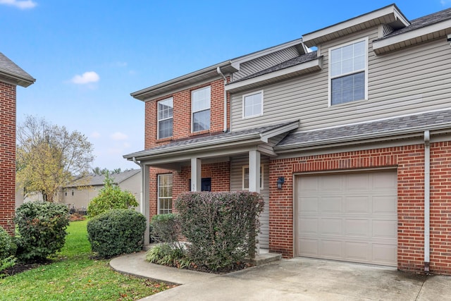 view of property featuring a garage, brick siding, and concrete driveway