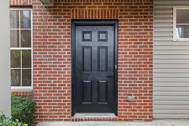 doorway to property with brick siding