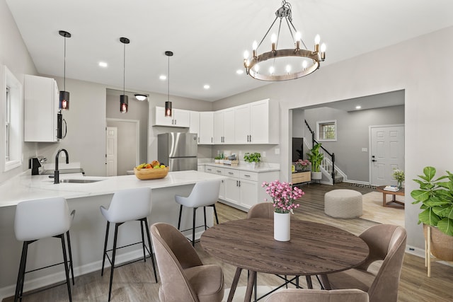 dining area with stairway, recessed lighting, light wood-type flooring, and baseboards