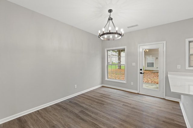 unfurnished dining area with visible vents, baseboards, dark wood-style floors, and a chandelier