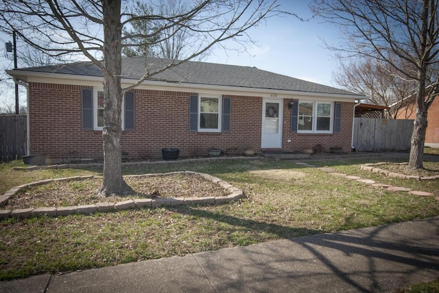 ranch-style house featuring brick siding, roof with shingles, a front yard, and fence