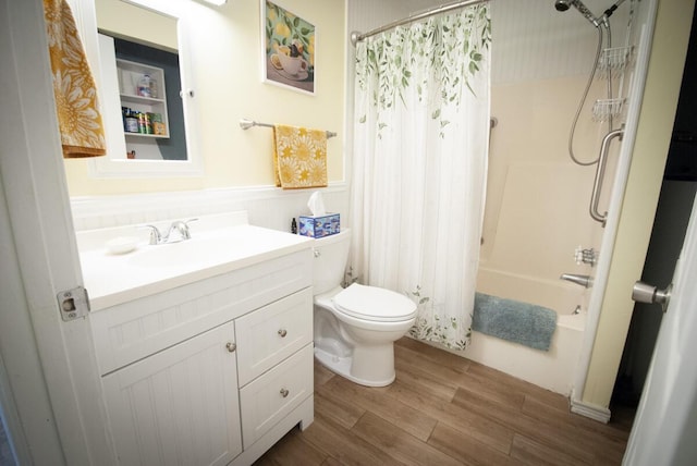 bathroom featuring a wainscoted wall, shower / bathtub combination with curtain, toilet, wood finished floors, and vanity