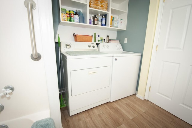 clothes washing area with light wood-style flooring, laundry area, and washer and clothes dryer