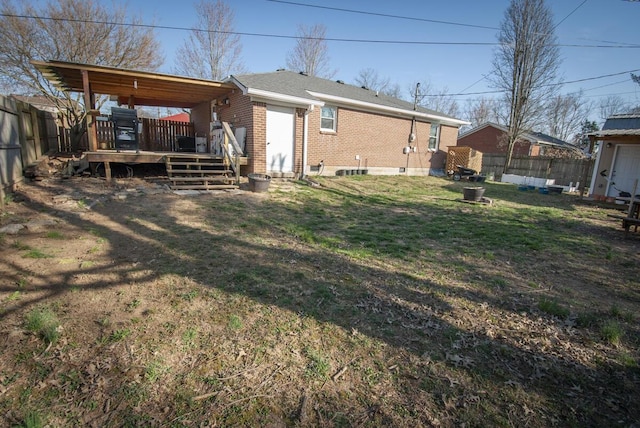 back of house with a lawn, a fenced backyard, brick siding, and a wooden deck