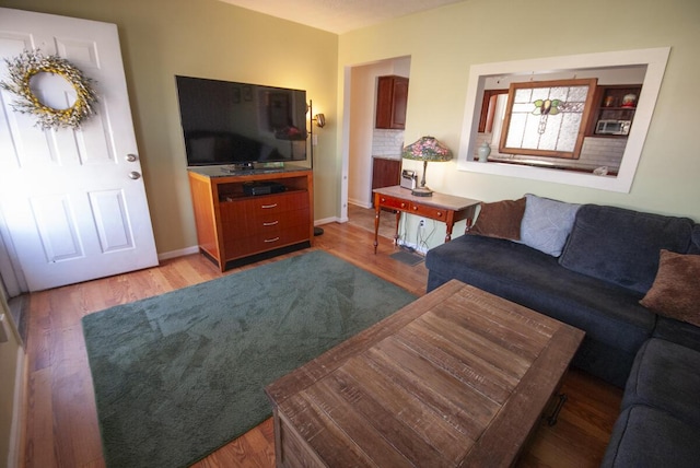 living room featuring light wood-type flooring and baseboards