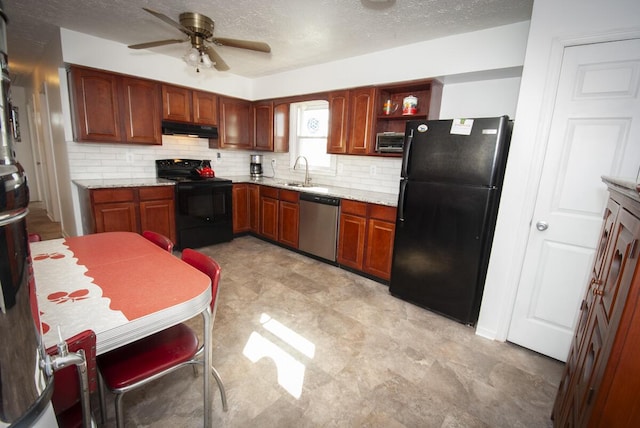 kitchen with light stone countertops, a sink, black appliances, under cabinet range hood, and backsplash