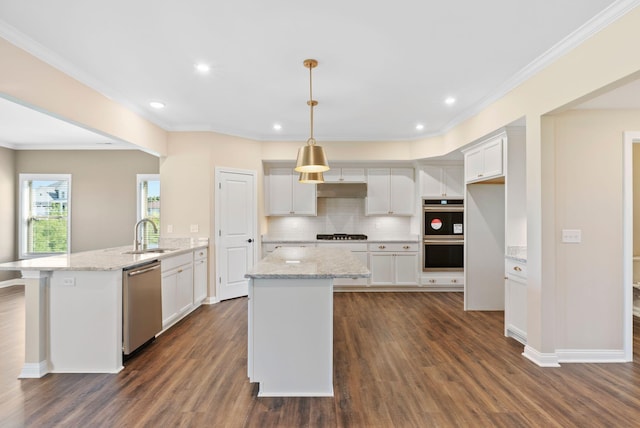 kitchen featuring appliances with stainless steel finishes, white cabinetry, a peninsula, and a sink