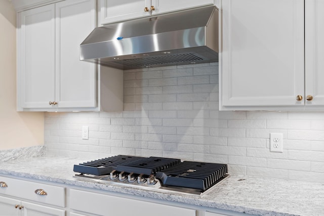 kitchen featuring under cabinet range hood, white cabinets, and stainless steel gas cooktop