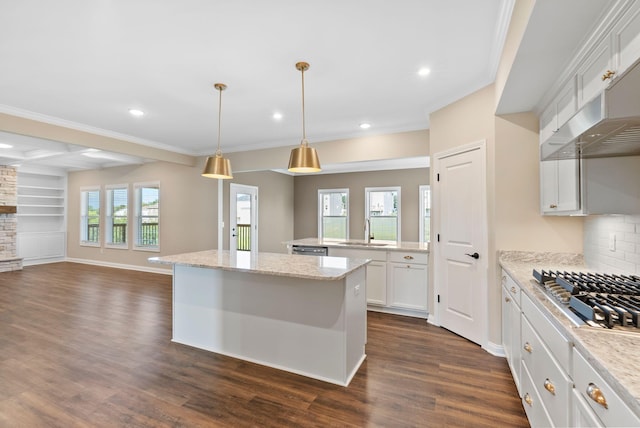 kitchen with a kitchen island, a sink, dark wood-type flooring, appliances with stainless steel finishes, and open floor plan