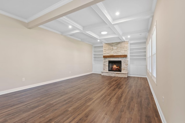 unfurnished living room with beamed ceiling, coffered ceiling, dark wood-style floors, a stone fireplace, and baseboards