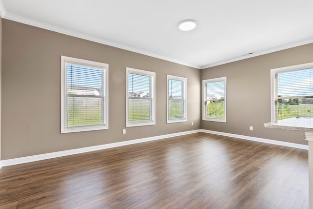 spare room with baseboards, dark wood-style flooring, and ornamental molding