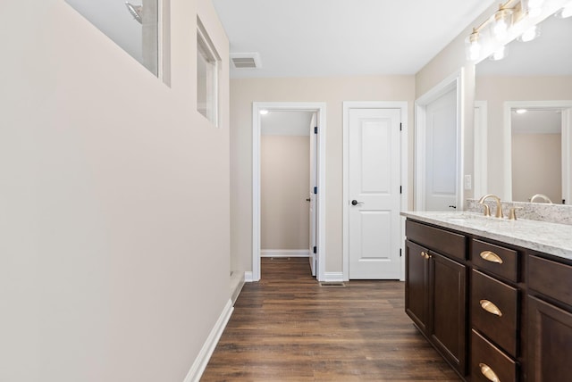 bathroom with vanity, wood finished floors, visible vents, and baseboards