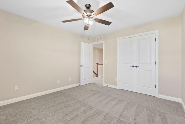 unfurnished bedroom with visible vents, a closet, carpet floors, baseboards, and ceiling fan