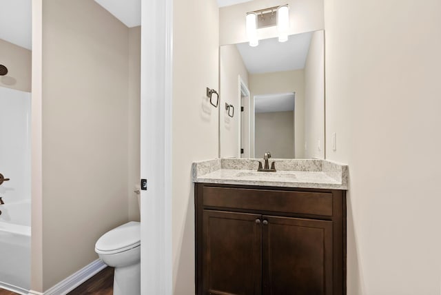 full bath featuring toilet, wood finished floors, vanity, baseboards, and shower / bathtub combination