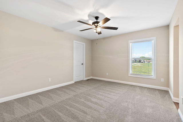 empty room featuring carpet flooring, baseboards, and a ceiling fan