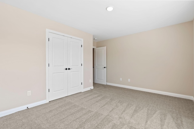 unfurnished bedroom featuring a closet, baseboards, and carpet