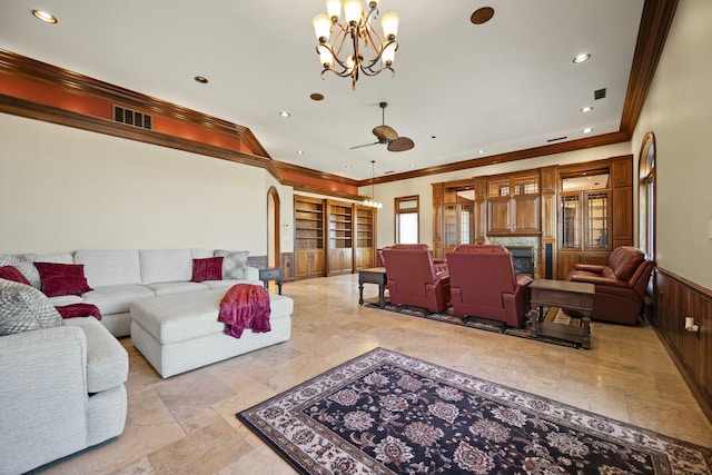 living area with visible vents, crown molding, recessed lighting, wainscoting, and a fireplace