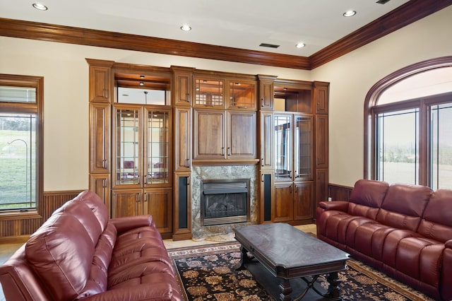 living area with visible vents, a premium fireplace, recessed lighting, wainscoting, and crown molding