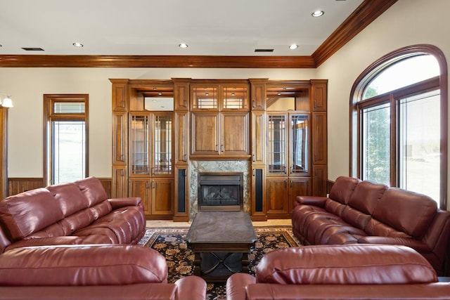 living room with visible vents, recessed lighting, wainscoting, crown molding, and a premium fireplace