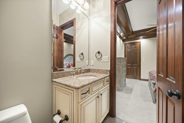 half bath featuring vanity, crown molding, toilet, and baseboards