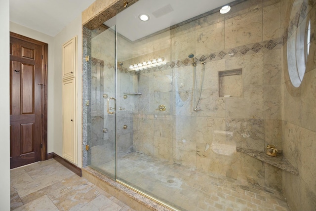 full bathroom with a shower stall and baseboards