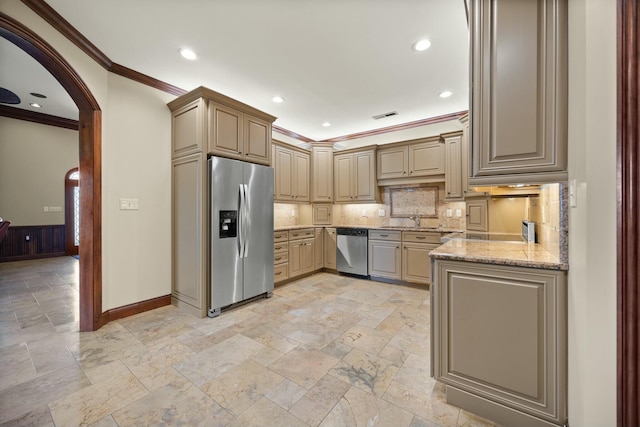 kitchen featuring visible vents, a sink, arched walkways, appliances with stainless steel finishes, and crown molding