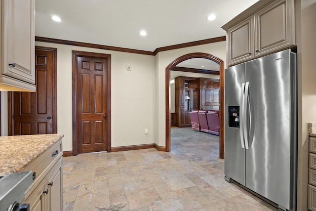 kitchen featuring light stone counters, baseboards, recessed lighting, stainless steel refrigerator with ice dispenser, and stone finish flooring