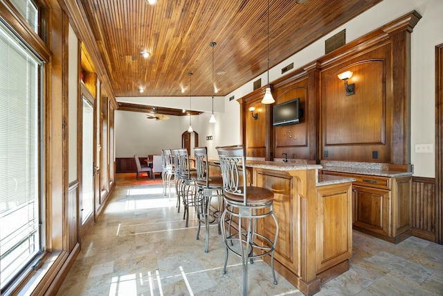 bar featuring hanging light fixtures, a healthy amount of sunlight, and wood ceiling