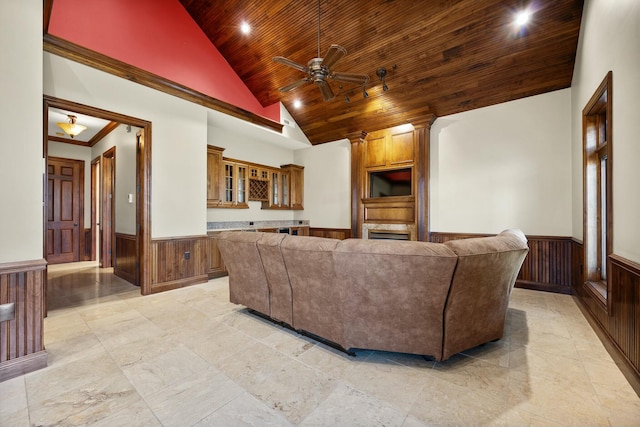 living room featuring wood ceiling, a wainscoted wall, wood walls, and high vaulted ceiling