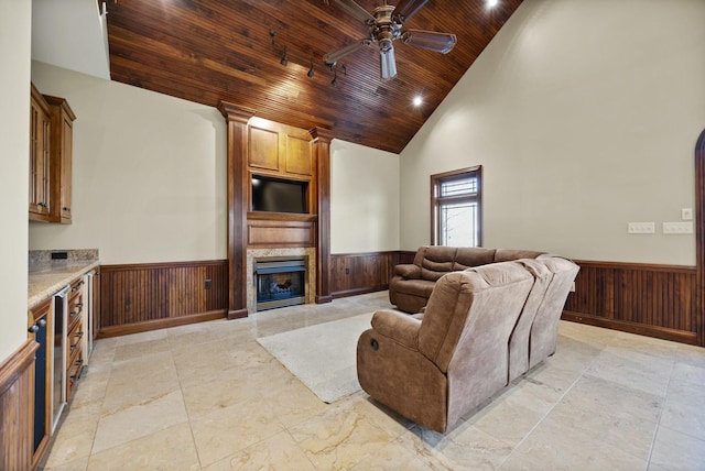 living area with a wainscoted wall, wood ceiling, and wood walls