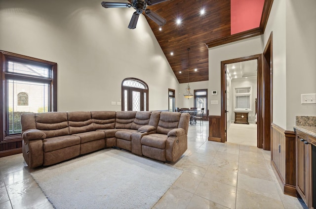 living area featuring high vaulted ceiling, wainscoting, wood ceiling, and a healthy amount of sunlight